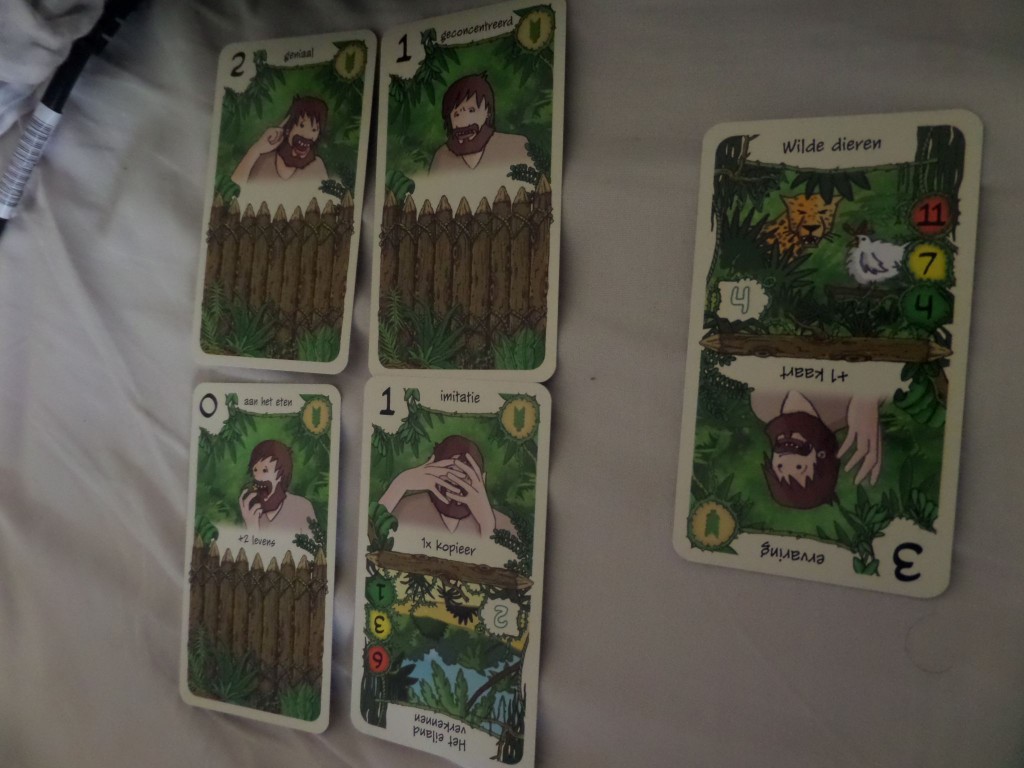 Een voorbeeldgevecht: Je moet de wilde dieren verslaan. Daarvoor heb je in de eerste ronde 4 punten nodig (in het groene bolletje) en mag je kosteloos 4 kaarten nemen (in het witte kadertje). Met de 4 getrokken kaarten lukt het net.